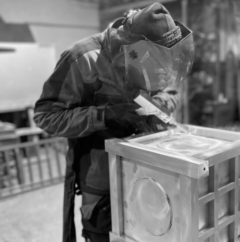 Exklusive pflanzkübel outdoor Hersteller beim Schweißen eines edlen Metall-Pflanzkübels in moderner Manufaktur und Premiumqualität
