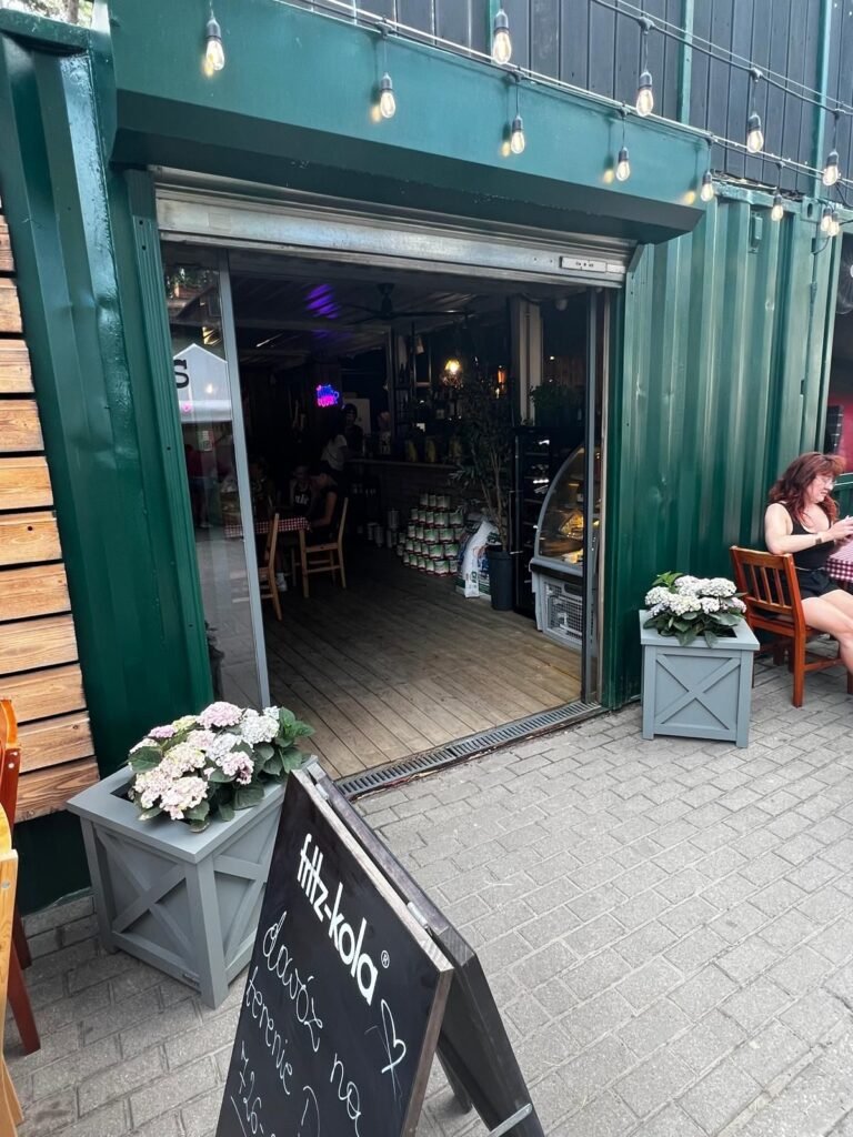 Graue Pflanzkübel mit Blumen vor einem Restaurant
